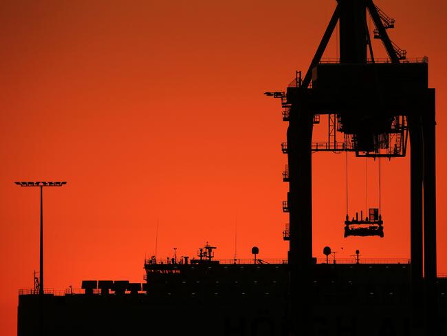 The sun sets over the Port Melbourne docks before temperatures are set to rise over 40 degrees in coming days. Picture: Mark Stewart