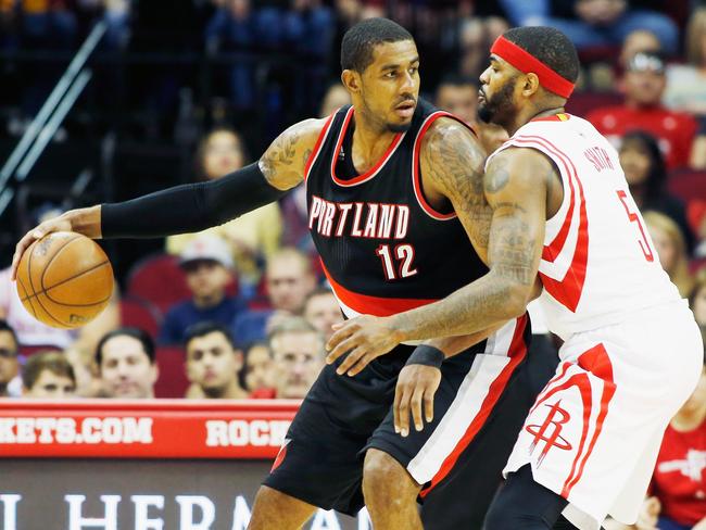 LaMarcus Aldridge of the Trail Blazers holds off Josh Smith of the Rockets.