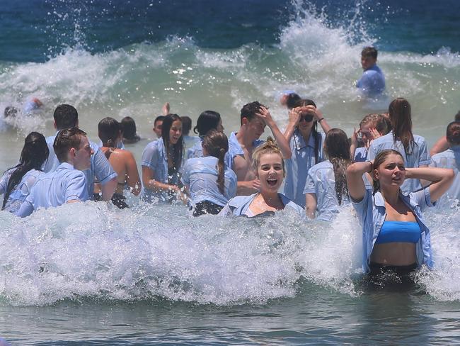 Nerang State High seniors swim in their uniforms at Surfers Paradise. Picture: Glenn Hampson