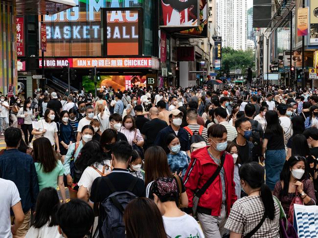 HONG KONG, CHINA - OCTOBER 30: Residents cross an intersection at a shopping district on October 30, 2022 in Hong Kong, China. The world's population is slated to reach 8 billion on November 15, according to the U.N. Hong Kong is one of the densest urban population centers in the world, with its developed areas reaching skyward to house its nearly 7,000 people per square kilometer in slender high rises along narrow tracts of land across the territory. (Photo by Anthony Kwan/Getty Images)