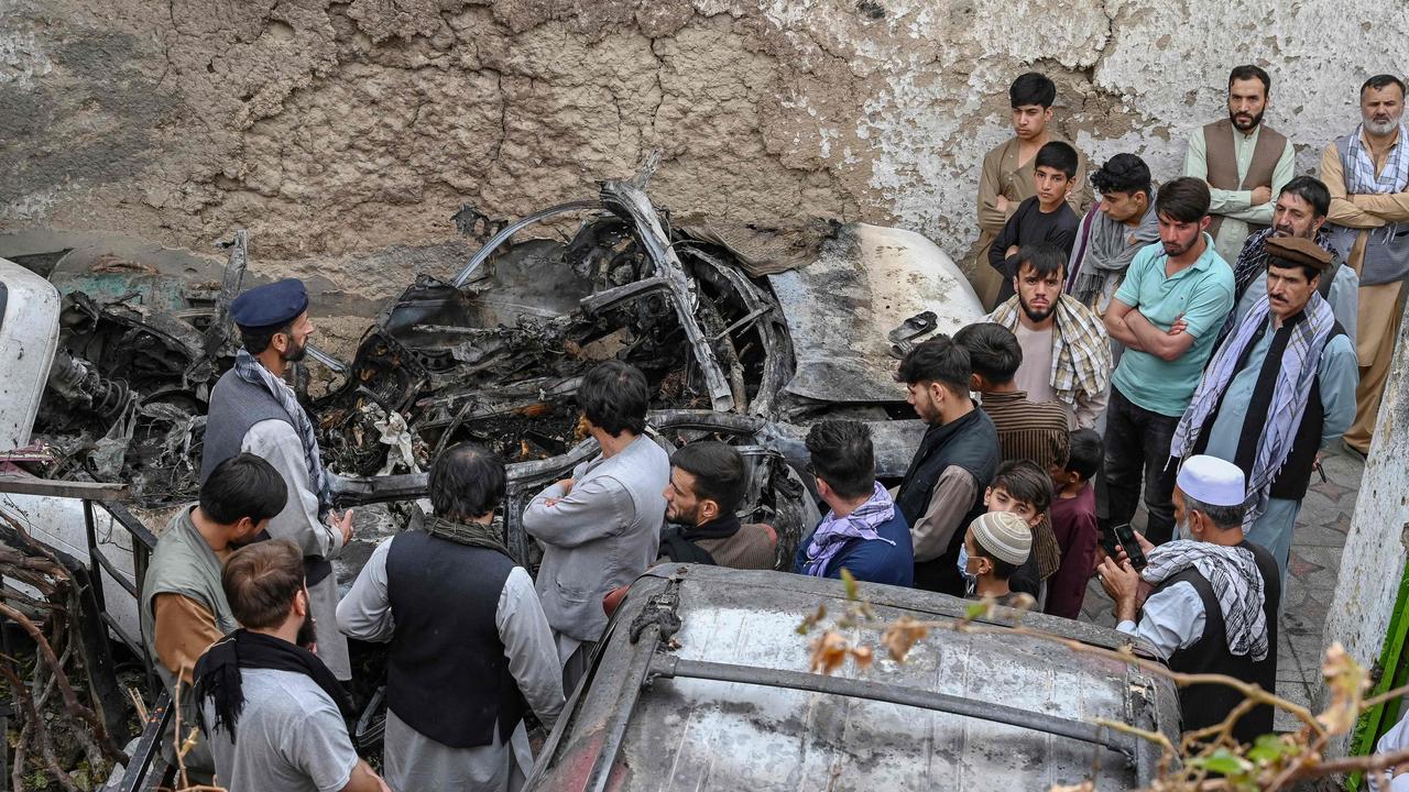 Afghan residents and family members of the victims gather next to a damaged vehicle inside a house, the day after a US drone air strike. Picture: Wakil Kohsar/AFP