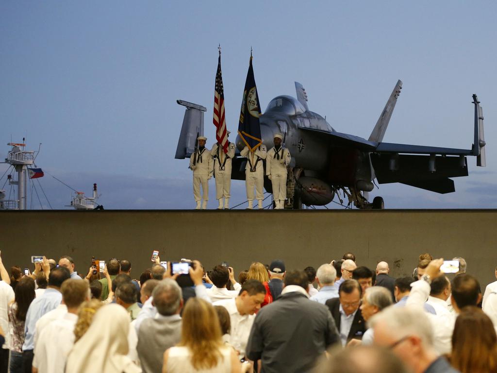 Guests take photos as a F-18 fighter jet is lowered for a ceremony aboard the US aircraft carrier USS Theodore Roosevelt while anchored off Manila Bay on Friday, April 13. Picture: AP