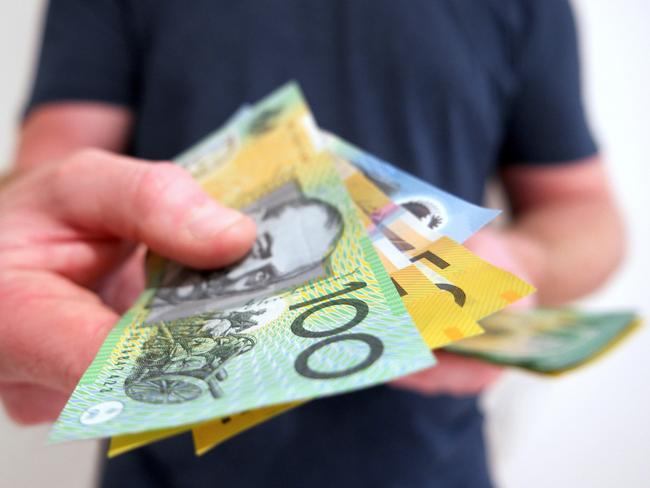 A man handing out Australian dollar bills. A picture that describes buying, paying, handing out money, or showing money.