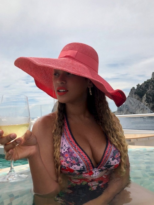 Beyoncé enjoys a glass of wine and her Camilla swimsuit.