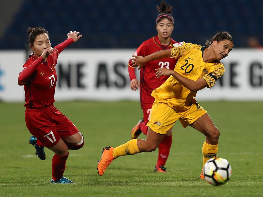 Samantha Kerr of Australia battles for the ball with Tran Thi Hong Nhung (L) and Pham Hoang Quynh (R) of Vietnam.