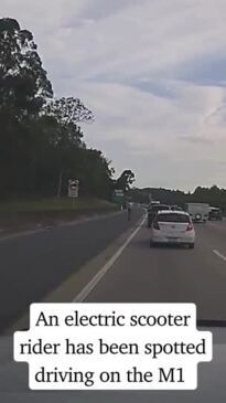 An electric scooter is seen being ridden on the M1