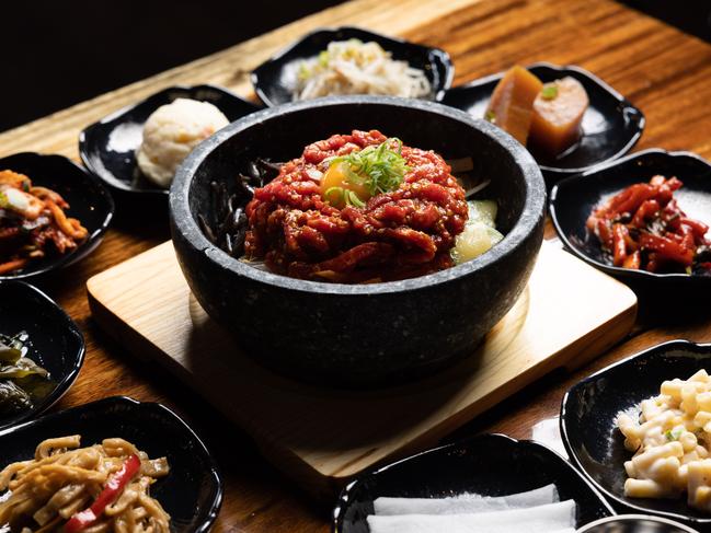 QWEEKEND RESTAURANT Daega Korean BBQ Cuisine. Bibimbap in Hot Stone Bowl - Raw Beef and assorted side dishes.Photograph David Kelly