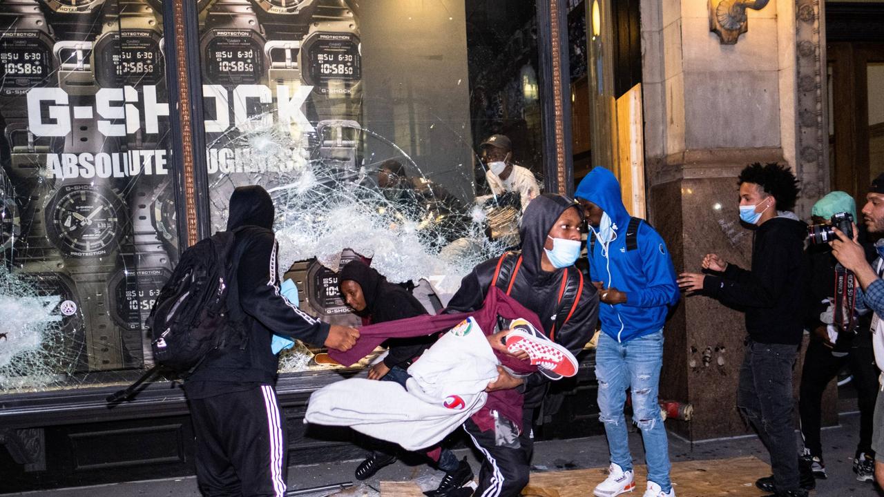 Shop windows are smashed as photographers look on. Picture: Stephen Yang / MEGA