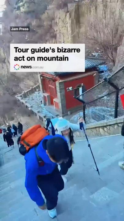 Tour guide's bizarre act on mountain - Tour guide rakes in cash by carrying fatigued females up the mountain