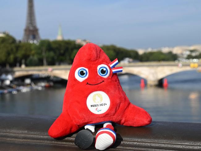 The Paris 2024 Olympics mascot, the Phrygian cap, symbol of revolutions, the French Republic and freedom, is placed on the railings of the Alexander III Bridge that crosses the River Seine, during the swim familiarisation event on the eve of a planned triathlon test races in Paris, on August 16, 2023. From August 17 to 20, 2023, Paris 2024 is organising four triathlon events to test several arrangements, such as the sports operations, one year before the Paris 2024 Olympic and Paralympic Games. (Photo by Bertrand GUAY / AFP)