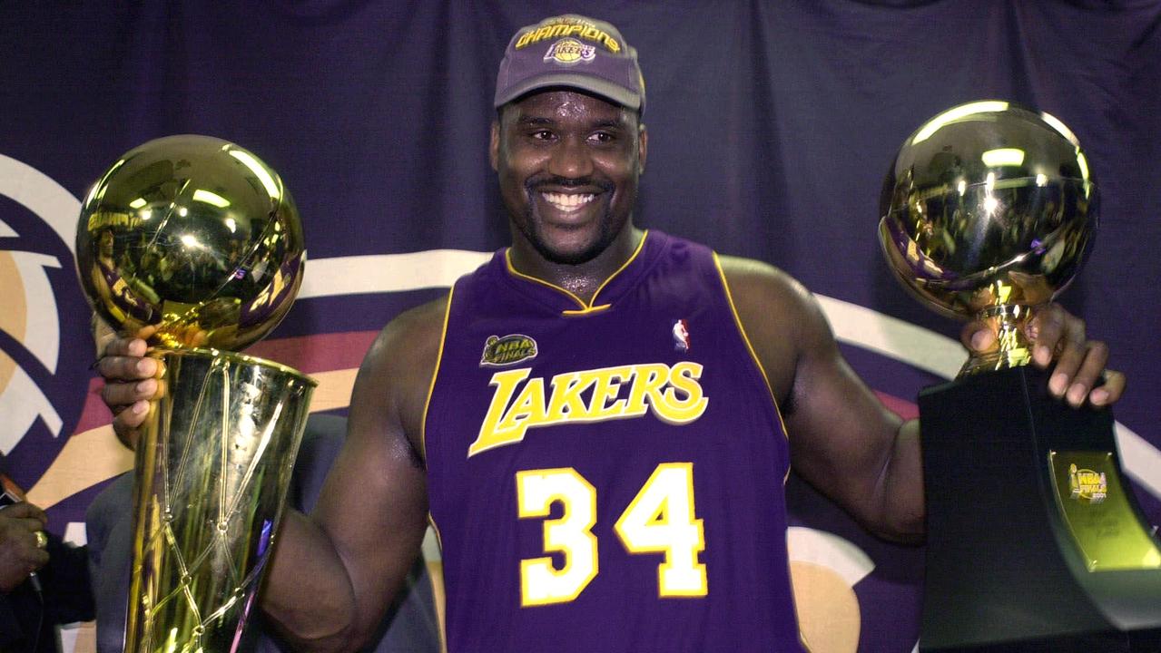 Los Angeles Lakers' Shaquille O'Neal holding up the MVP trophy, (R), and the championship trophy after the Lakers won their second straight NBA championship in 2001.