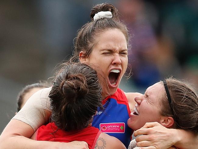 MELBOURNE, AUSTRALIA - MARCH 24: Emma Kearney of the Bulldogs (second from left) celebrates a goal with teammates L-R Ellie Blackburn, and Kirsty Lamb during the 2018 AFLW Grand Final match between the Western Bulldogs and the Brisbane Lions at IKON Park on March 24, 2018 in Melbourne, Australia. (Photo by Adam Trafford/AFL Media/Getty Images)