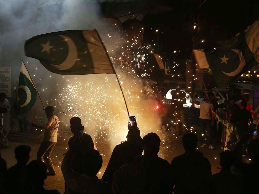 Pakistanis wave the national flag as they celebrate after the short-lived ceasefire declaration between Pakistan and India. Picture: Husnain Ali/AFP