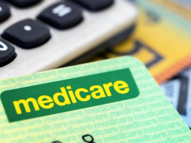 Australian Medicare card with calculator and cash background.