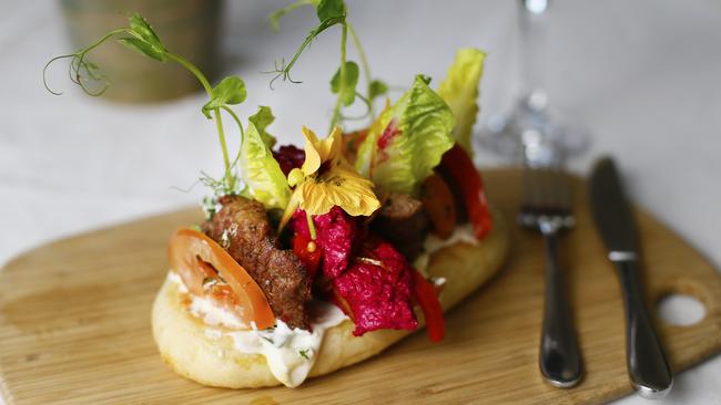 Lightly-spiced ground lamb burger served with flat bread, preserved lemon, salad leaves, mint, fresh tomato, beetroot hummus and tzatziki. Picture: MATT THOMPSON