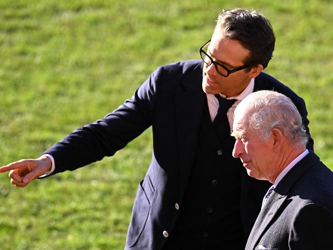 Ryan Reynolds gestures towards the team's players as he talks with Britain's King Charles. Picture: AFP