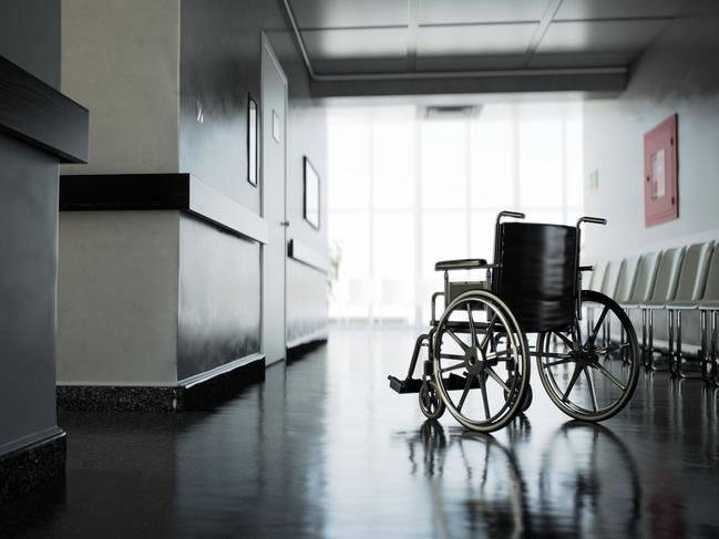 Standard manual wheelchair standing in empty hospital corridor