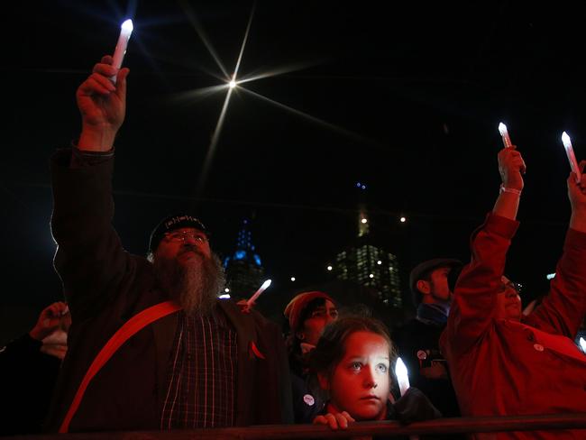 Members of the public hold candles to mourn the victims of HIV/AIDS and the victims of flight MH17 during a candlelight vigil at Federation Square. At least six delegates travelling to the 20th International AIDS Conference were on board the Malaysia Airlines flight MH17. Picture: Getty