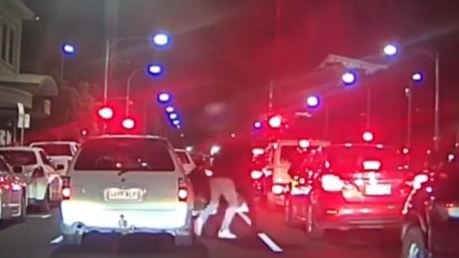 Footage obtained by 7NEWS shows a white car swerving across lanes and cutting off a mini-van on Currie Street as it moves into the left lane before two men get into a brawl. Picture:7NEWS