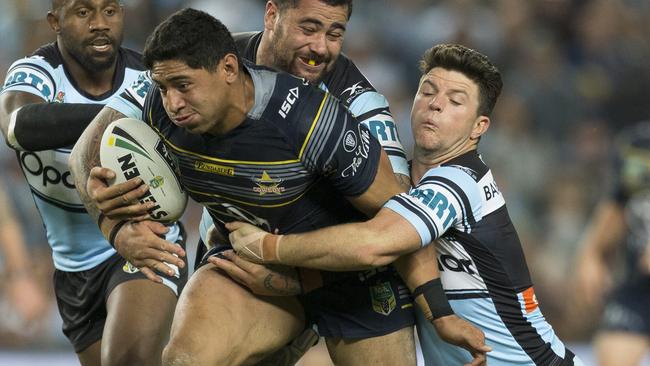 Jason Taumalolo of the Cowboys is tackled by Andrew Fifita and Chad Townsend of the Sharks.