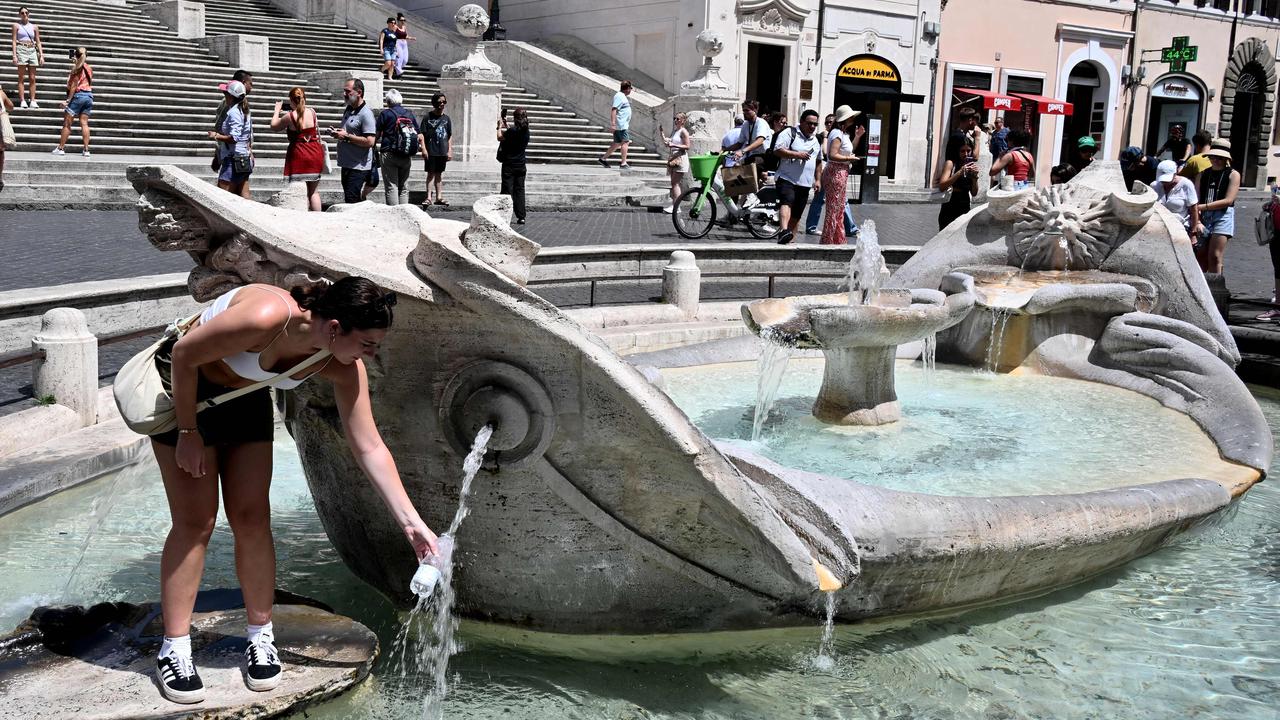 A woman fills a bottle with water at the Barcaccia fountain in front of the Scalinata di Trinita dei Monti (Spanish Steps) in Rome. Picture: AFP