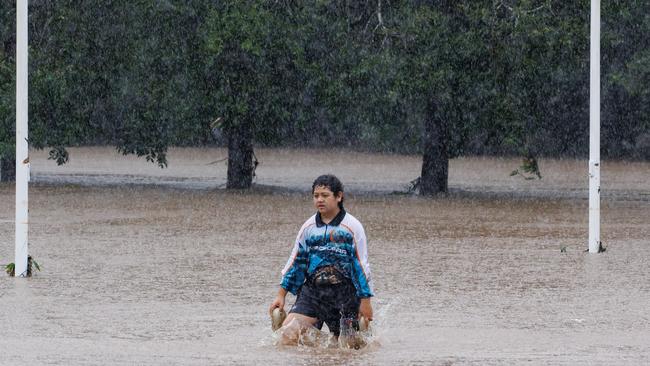 A young girl walks through flood waters at Quota Park at Nambour Picture Lachie Millard