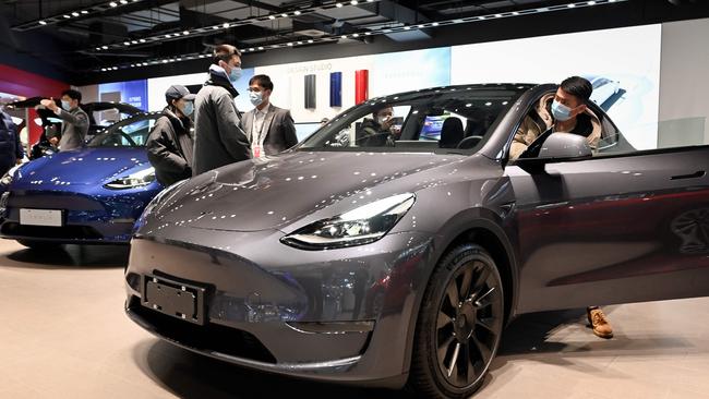 Potential buyers look at a Tesla Model Y car at a showroom in Beijing. Picture: AFP