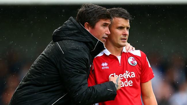 Harry Kewell, manager of Crawley Town talks to Dean Cox of Crawley Town.