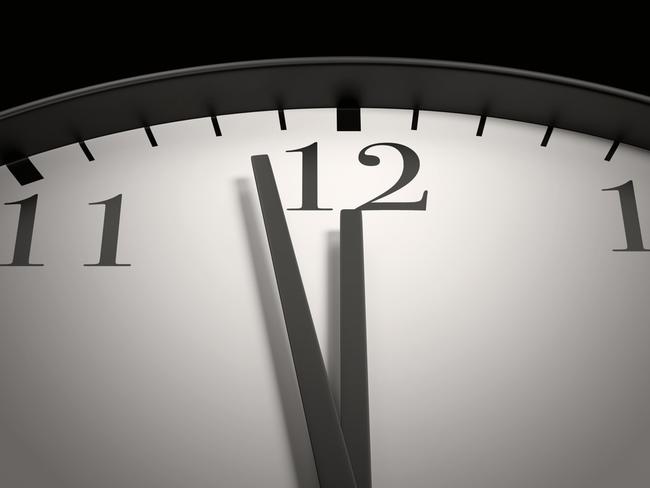 Round black and white clock with both the hour hand and minute hand almost pointing to 12 o'clock. Illustration of the concept of due date, deadline, countdown and doomsday