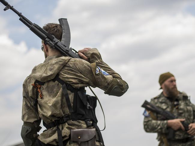 Pro-Russia rebels guard the area around the wreckage of Malaysia Airlines flight MH17 during monitoring by investigators.