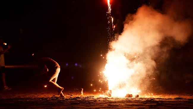 A punter gets a bit too close for comfort whilst lighting off fireworks ahead of the fireworks show at Mindil Beach on Sunday night for the Territory Day celebrations. Picture: Justin Kennedy