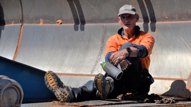 A lone protester sits in the scoop of a bulldozer at the site of Defence Housing Australia's development site in Lee Point. Picture: Sierra Haigh