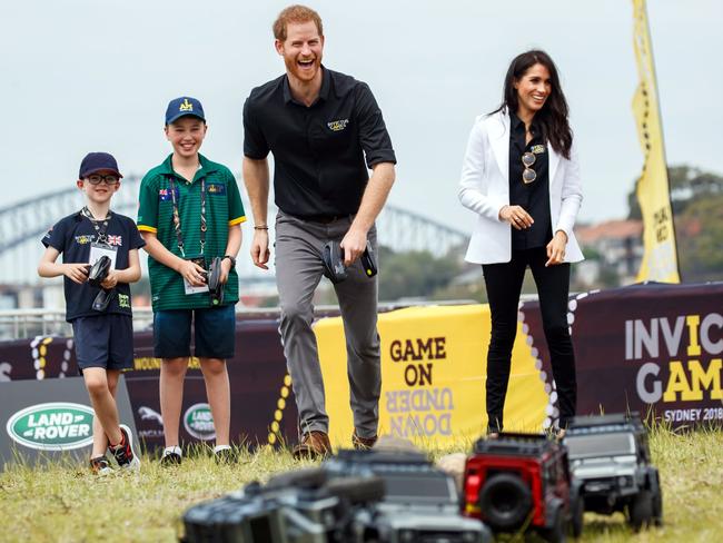 Prince Harry, Duke of Sussex and Meghan, Duchess of Sussex controls remote control car during the JLR Drive Day at Cockatoo Island. Picture: Invictus Games