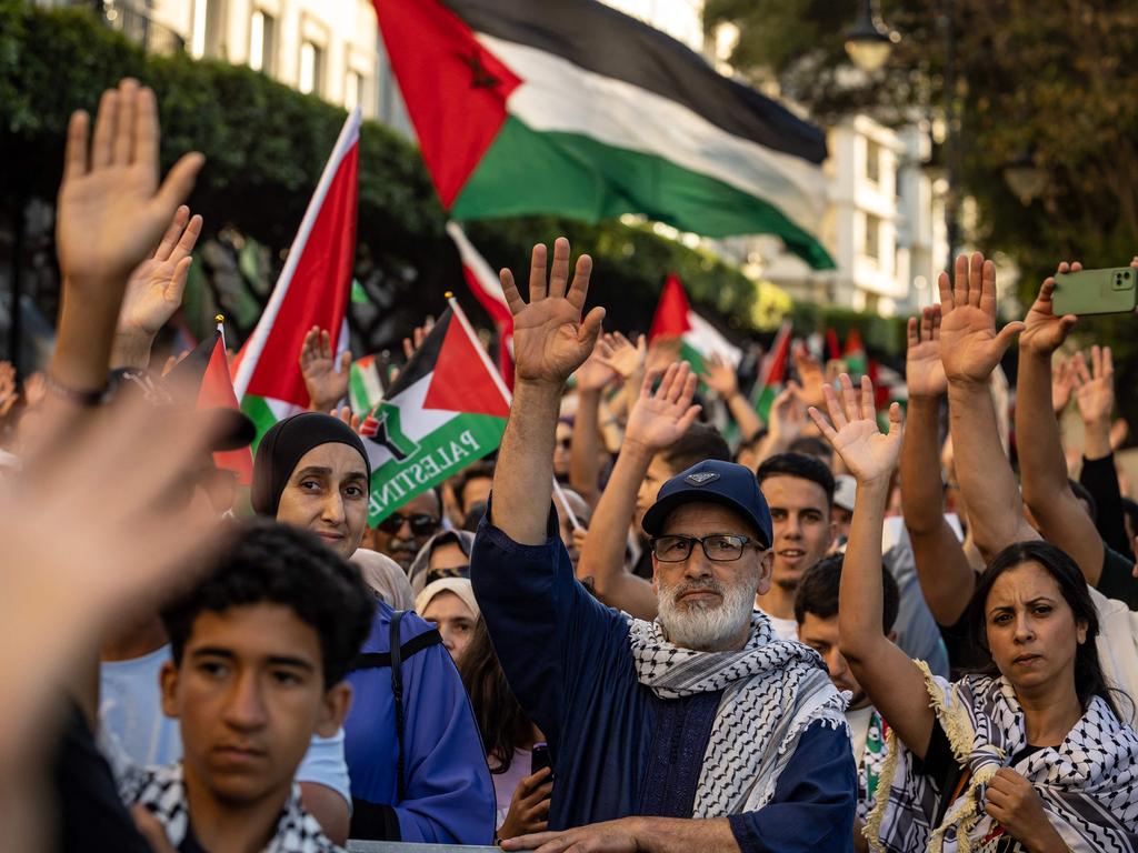People wave Palestinian national flags and raise their hands during a march in solidarity with the people of Gaza in the city of Tangier. Picture: Fadel Senna/AFP
