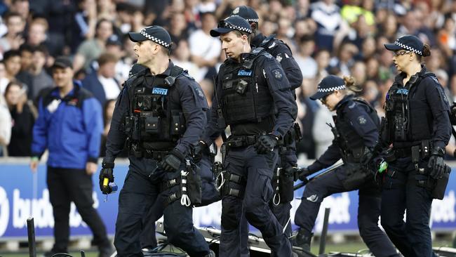 Victoria Police on the pitch after fans stormed the ground during the Round 8 A-League at AAMI Park. Picture: Darrian Traynor