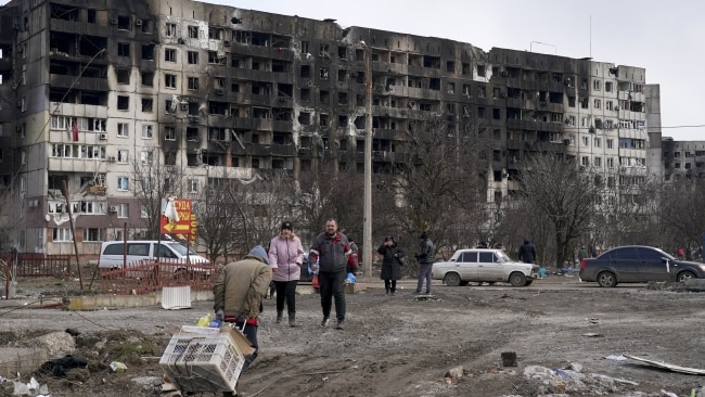 Residents in Mariupol leaving destroyed apartment blocks. Tens of thousands of locals remain trapped. Picture: Getty Images