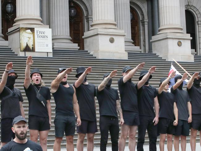 Far right wing group does Nazi salutes on the steps of parliament during an anti-trans rally in Melbourne. Picture: David Crosling