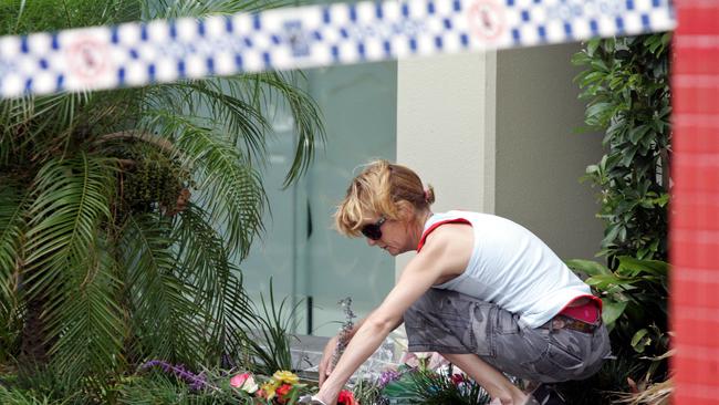 A woman lays flowers at the scene of the murder of store owner Frank Newbery, 87, in Union Street, Newcastle.