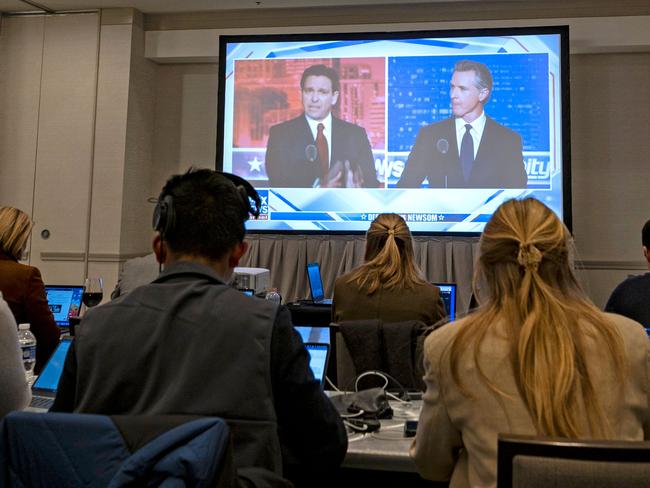 Florida Governor and Republican presidential hopeful Ron DeSantis (L) and California Governor Gavin Newsom (R) appear on screen from the press room during a debate held by Fox News, in Alpharetta, Georgia, on November 30, 2023. (Photo by Christian MONTERROSA / AFP)