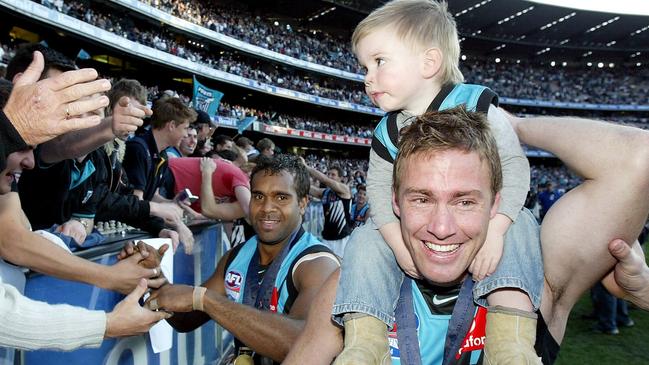 Schofield with son Taj on the MCG after the 2004 Grand Final. Taj is now looming as a father/son draftee at the Power.