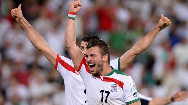 Soroush Rafiei and Morteza Pouraliganji of Iran celebrate the late goal.