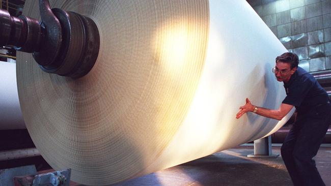 A worker handles a roll of paper at the Maryvale mill. Picture: Simon Schluter 