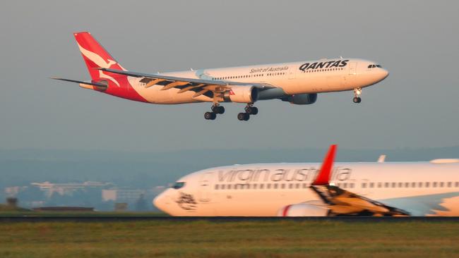 A Qantas Airbus A330-303 plane, registration VH-QPB, coming into land from the south on the main runway of Sydney Kingsford-Smith Airport as flight QF128 from Hong Kong. In the foreground is a Virgin Australia Boeing B737-8FE plane, registration VH-YFZ, taxiing before departure as flight VA1528 to Hobart.  This image was taken from Mill Stream Lookout, Botany Bay on a sunny morning at sunrise on 30 March 2024.27 October 2024Kendall HillPhoto - iStock