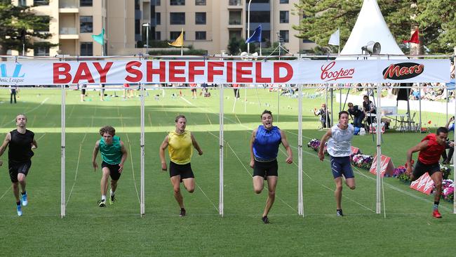 Ryan Atkins, in blue, wins the 130th Bay Sheffield men’s race at Glenelg last year. Picture: Dylan Coker