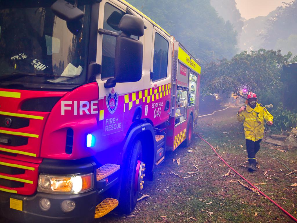 An out of control fire ripped through the Blue Mountains this afternoon. Unknown houses and other property has been destroyed along Bells Line of Road from Bilpin to Mount Tomah and further west. Firefighters rush to protect a burning industrial shed full of burning plastics. Picture: Matrix