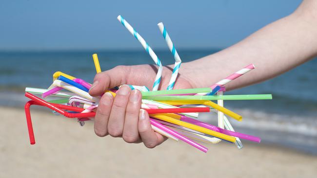 Close Up Of Hand Holding Plastic Straws Polluting Beach