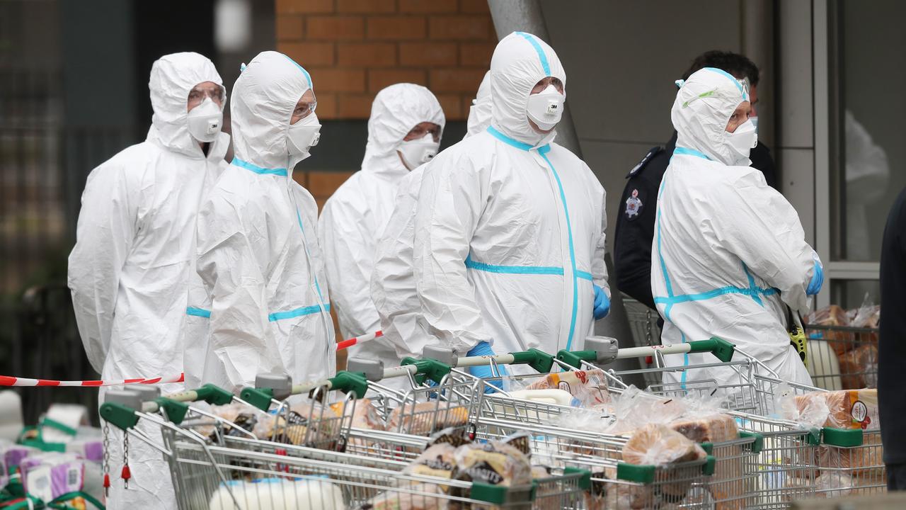 Firefighters in protective suits deliver food to the Towers in North Melbourne which were forced into lockdown by the government due to COVID-19. Picture: David Crosling