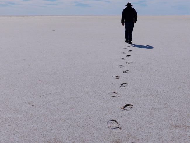 Charles Wooley walks out on the southern section of a Lake Eyre where it is a blinding white, salt pan stretching to the horizon during the filming of his program for Channel 7's Spotlight. For his col in Mercury. MUST CREDIT Arron Hage