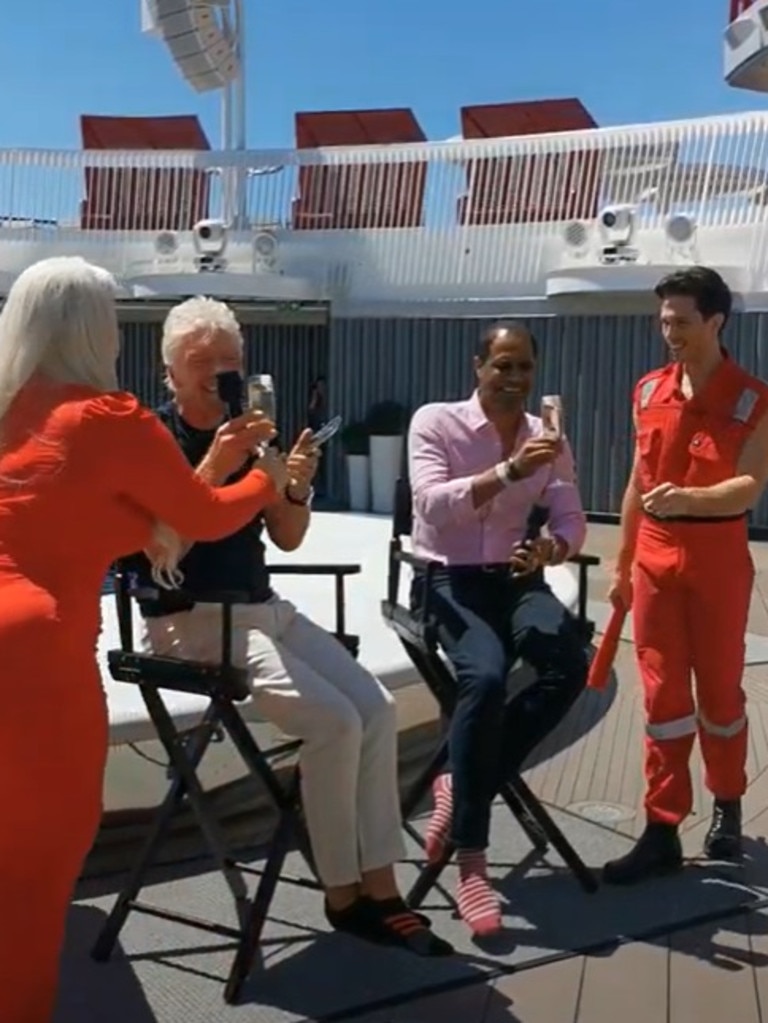 Here is rocking his socks and drinking a glass of champagne. (Passengers can shake their phones have a bottle delivered to their room in minutes). Picture: news.com.au