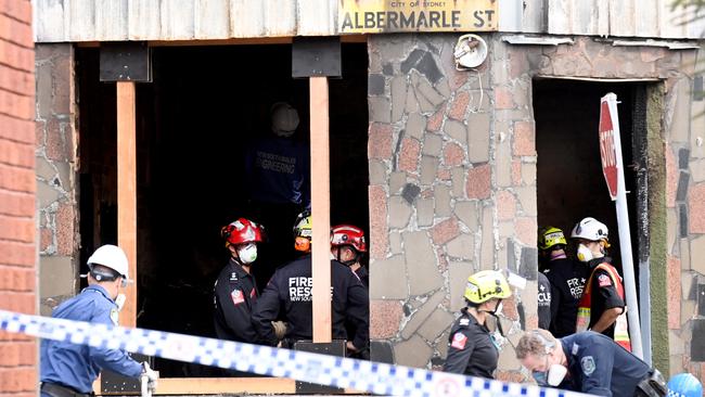 Investigators in March inspect the burnt premises of the house. Picture: Jeremy Piper